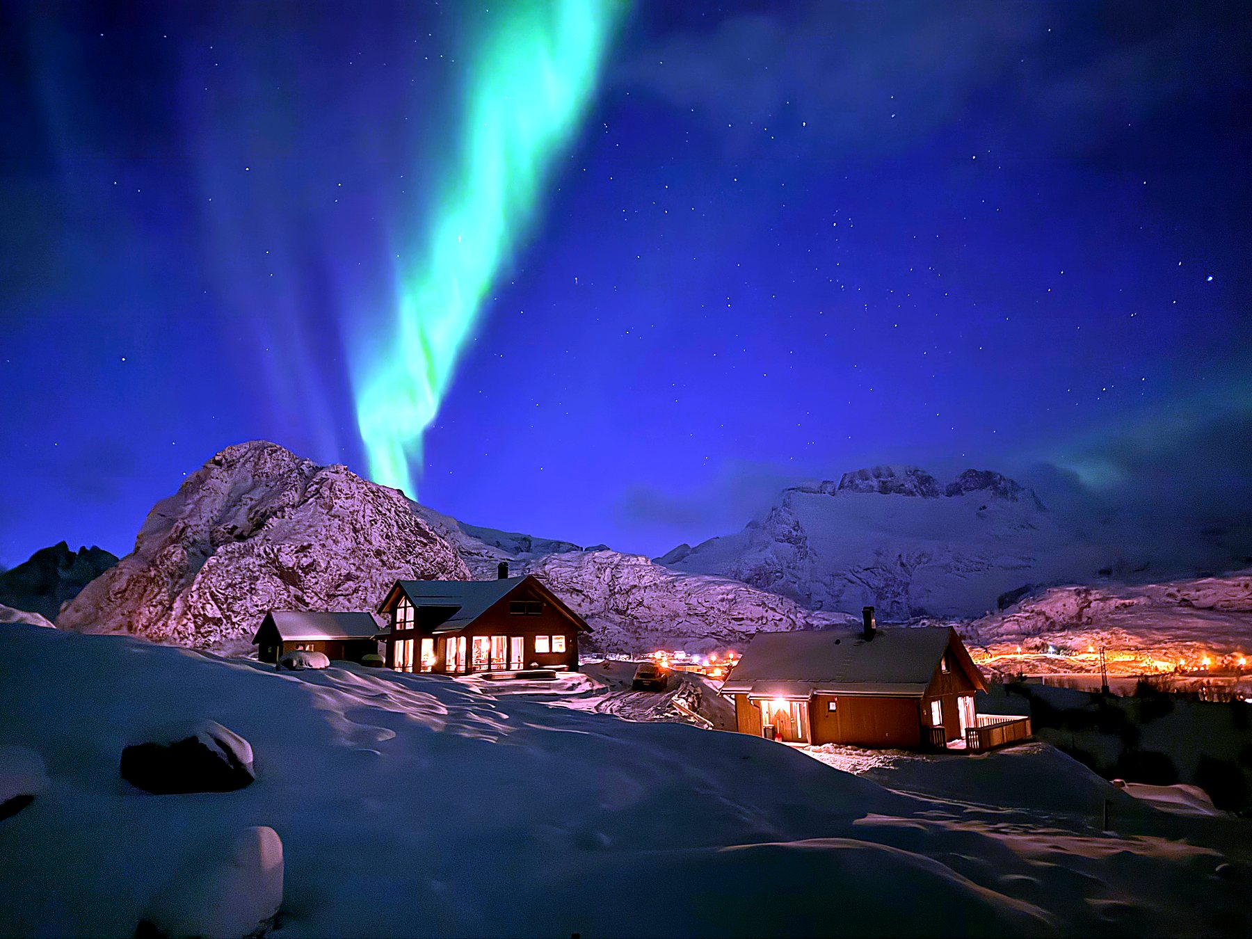 Gyllen kveld med nordlys over hyttene